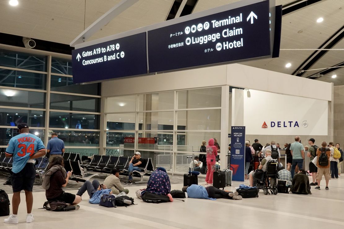 Travelers wait in a long line to speak with a Delta representative at the help desk in the McNamara terminal at the Detroit Metropolitan Wayne County Airport on July 20.